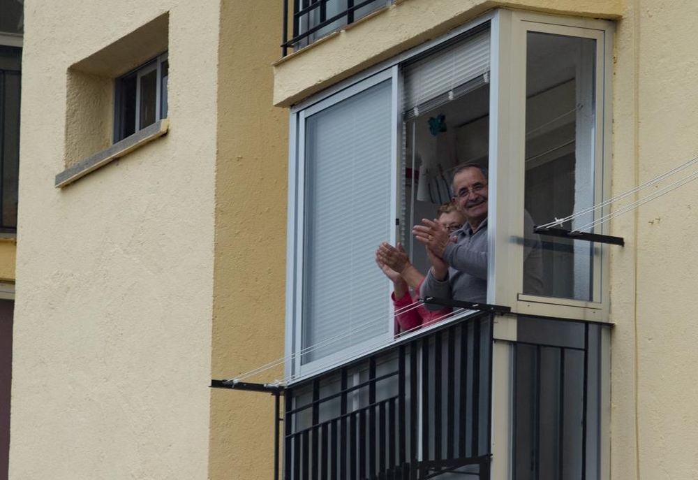 Puntuales a las ocho, los vecinos de El Teso salen a aplaudir junto a sus vecinos.  / DAVID CASTRO