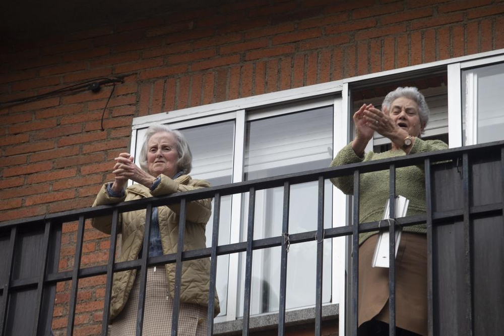 Puntuales a las ocho, los vecinos del barrio de Santiago salen a aplaudir junto a sus vecinos.  / DAVID CASTRO