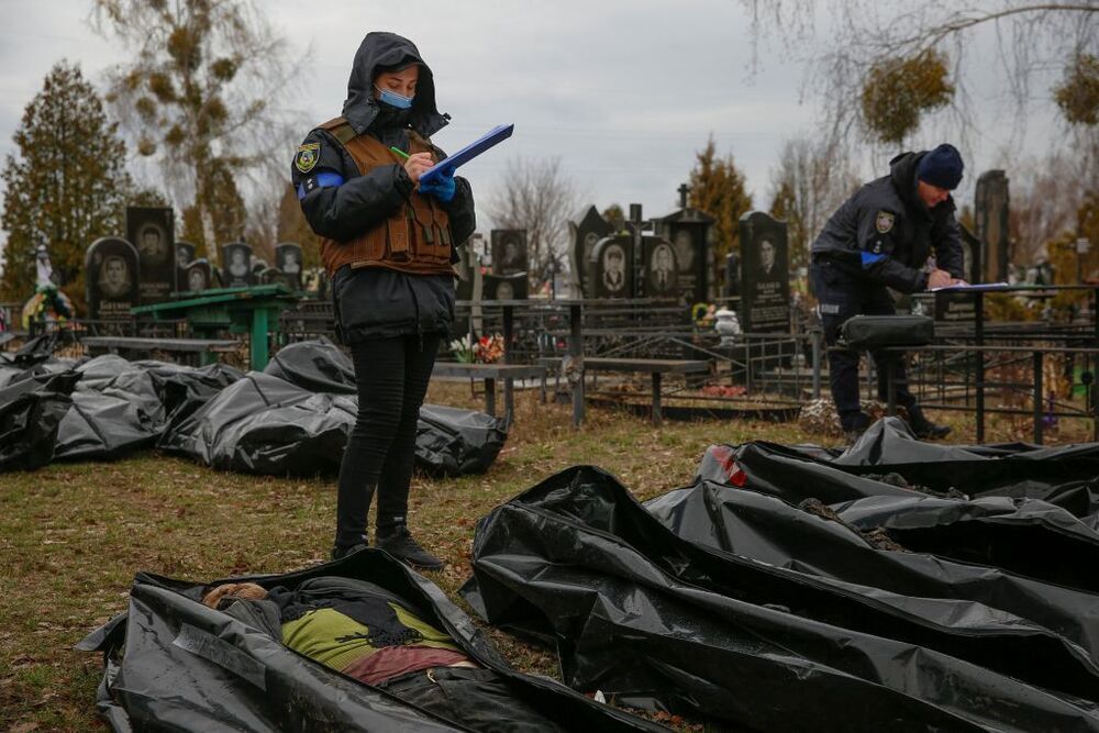Un grupo de agentes y operarios del cementerio de Bucha identifican los cuerpos de decenas de víctimas.